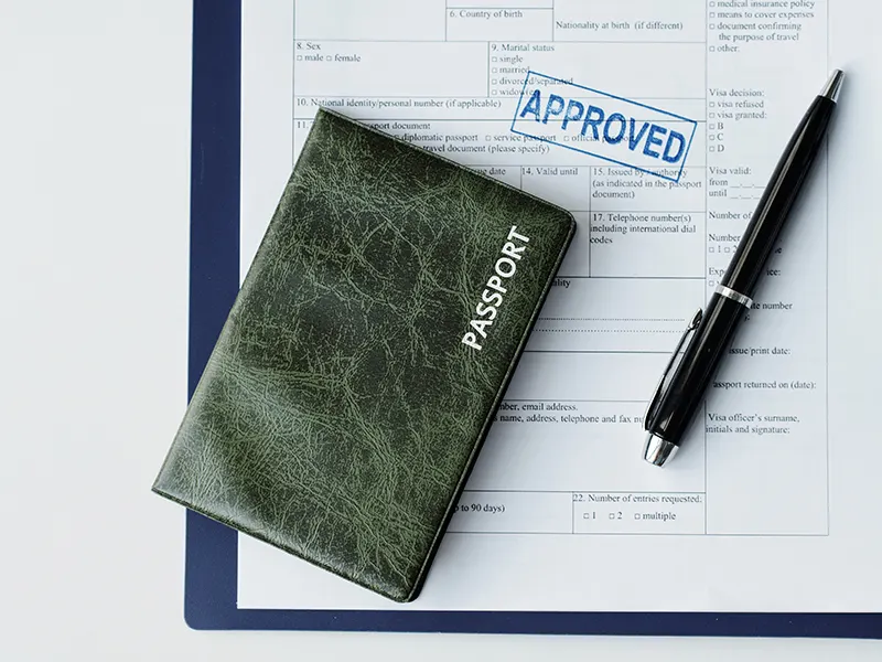 A passport on top of a stamped visa application form