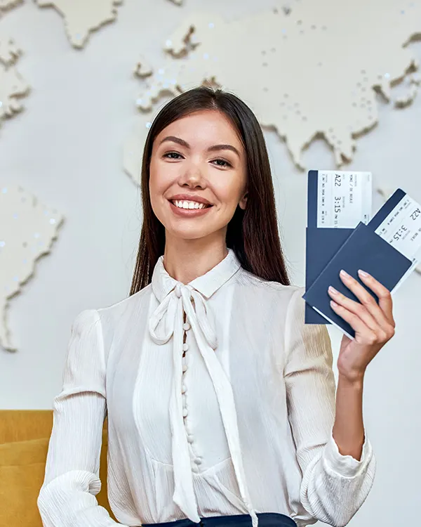A smiling travel agent holding passports and flight tickets