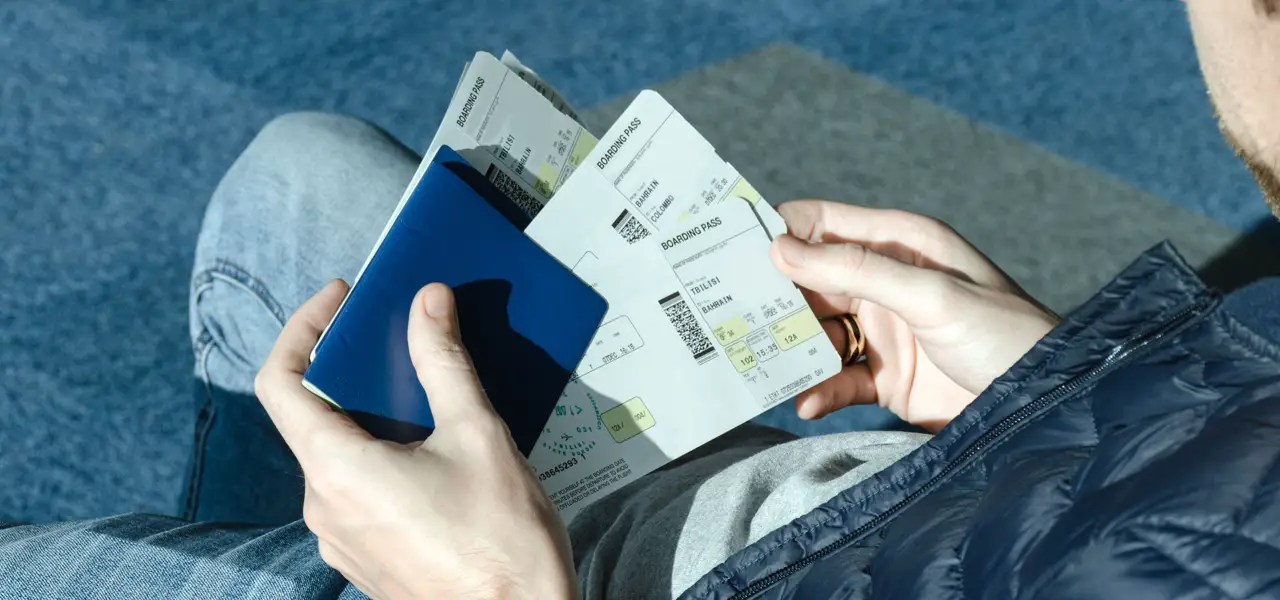 A traveller holding a passport and boarding passes